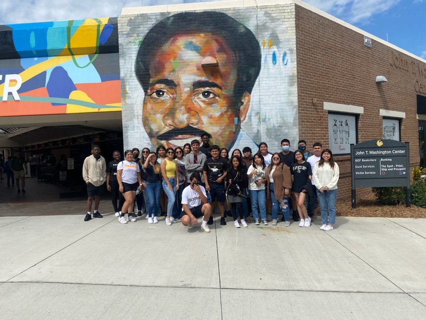 Immokalee Foundation juniors and postsecondary students pose in front of a mural at University of Central Florida.