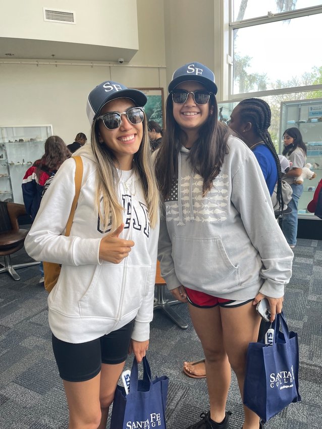 Marianna B., and Jenesis S. donning Santa Fe College hats and bags after the tour.