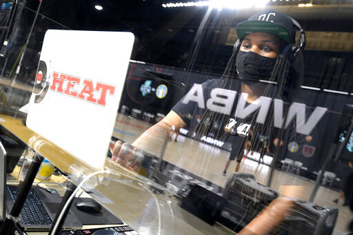 Nicole Mosley, who goes by her stage name DJ Heat, performs music behind glass partitions during warmups before a WNBA basketball game between the Chicago Sky and the New York Liberty, Tuesday, Aug. 25, 2020, in Bradenton, Fla. Performing in the WNBA bubble at games presents a new experience for DJs and announcers since there are only a handful of people in attendance at games besides the players. (AP Photo/Phelan M. Ebenhack)
