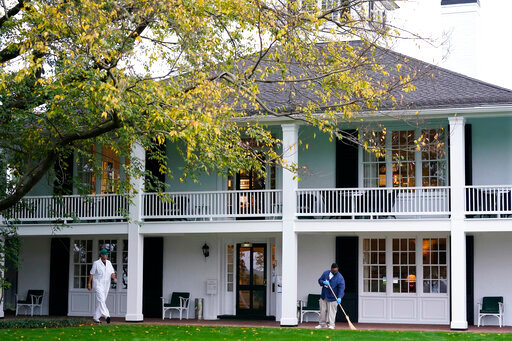 A worker sweeps leaves in front of the Augusta National Club house during a practice round for the Masters golf tournament Tuesday, Nov. 10, 2020, in Augusta, Ga. (AP Photo/David J. Phillip)