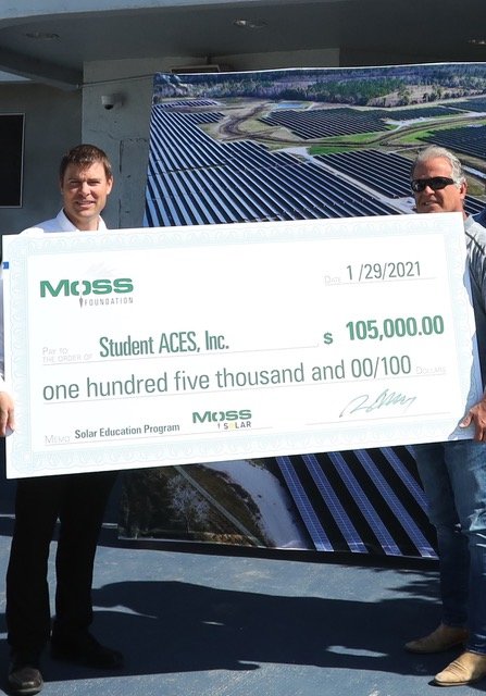 Mark Sochacki, Vice President/ Project Executive, Moss Construction, presents a $105,000 donation to Student ACES founder Buck Martinez at the organization's center in Belle Glade.