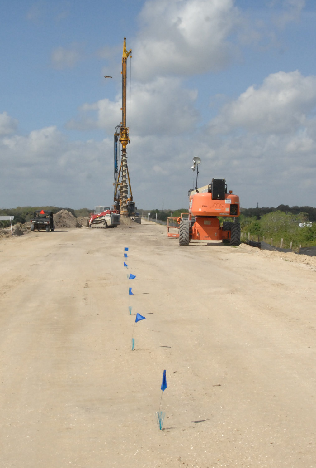 The blue flags mark the path for the pre-drilling machine which prepares the site for the Concrete Slurry Machine.