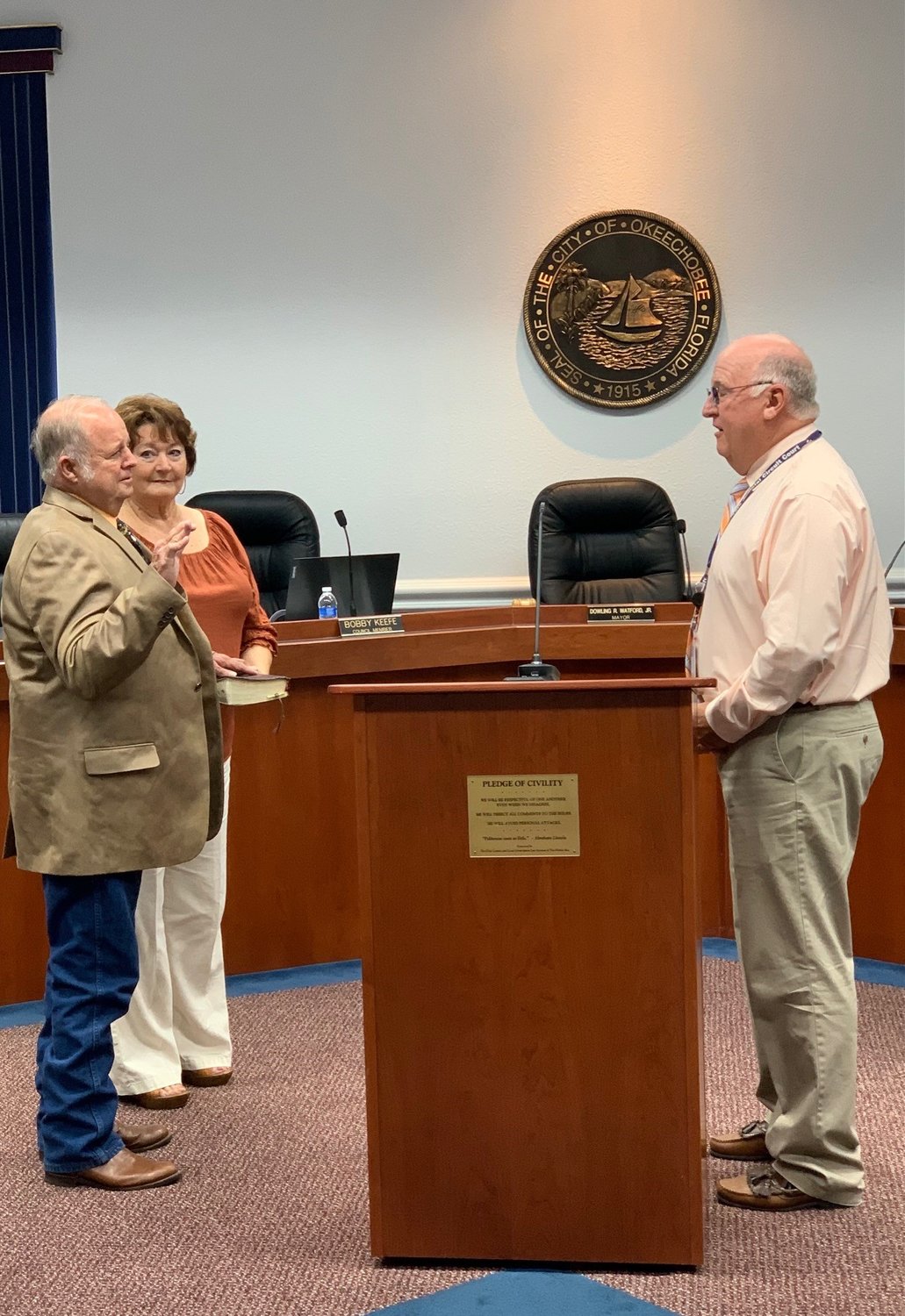 Judge Bill Wallace (right) administers the oath of office for Noel Chandler as he is sworn in for his term as city council member. Chandler's wife Louise holds the Bible used in the ceremony.