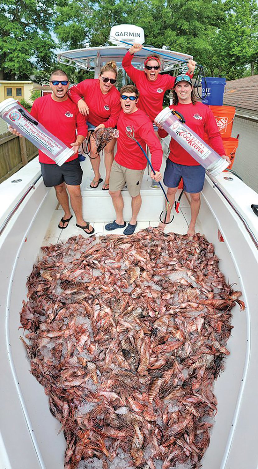 Holden Harris, center, with fellow lionfish removal enthusiasts, celebrating their haul of invasive lionfish.