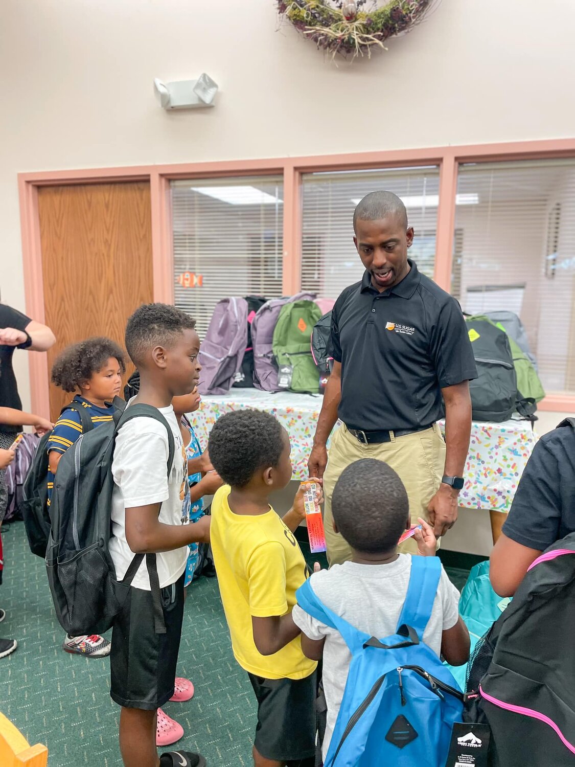 On July 25, 2023, U.S. Sugar Community Relations Director Brannan Thomas talks about the upcoming school year with local students from Clewiston.